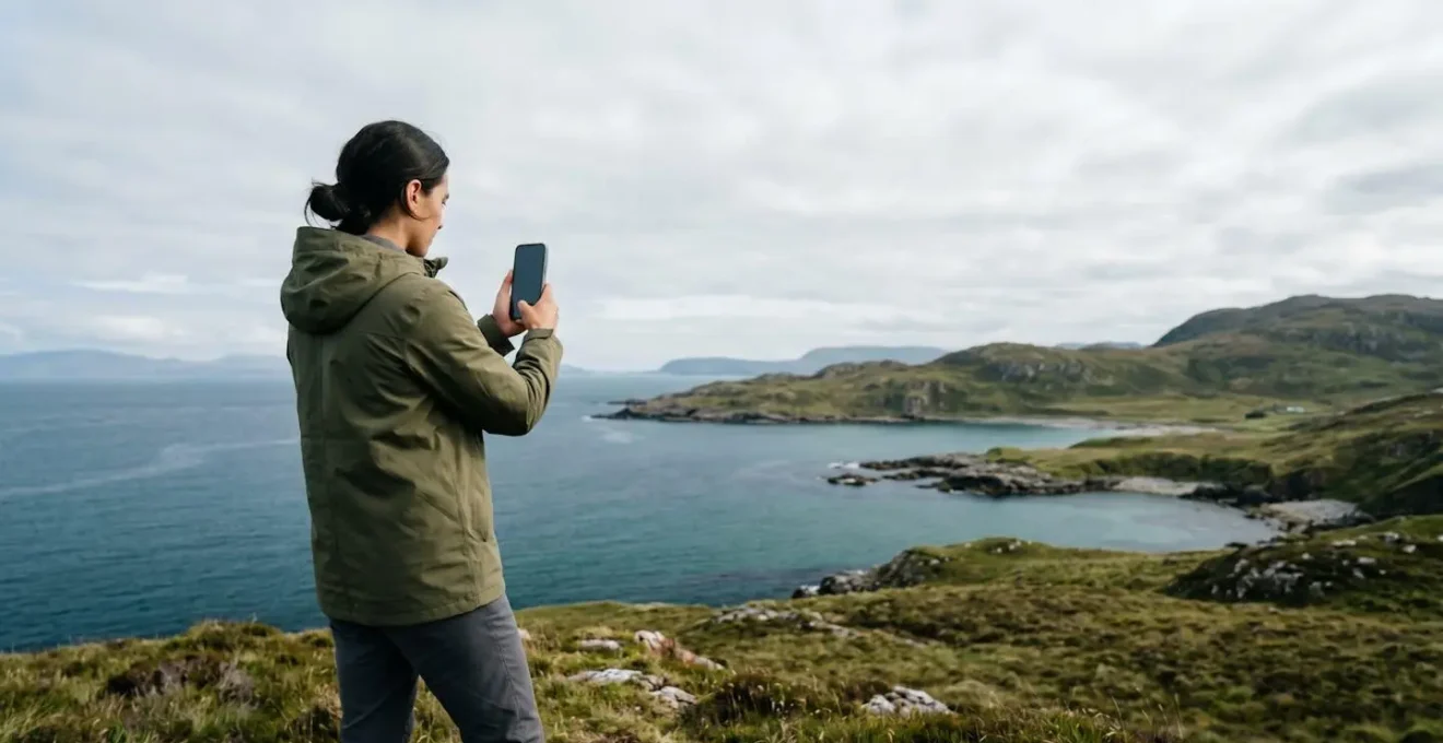 Personne utilisant un smartphone dans un environnement naturel évoquant l'équilibre entre technologie et environnement