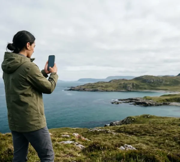 Personne utilisant un smartphone dans un environnement naturel évoquant l'équilibre entre technologie et environnement